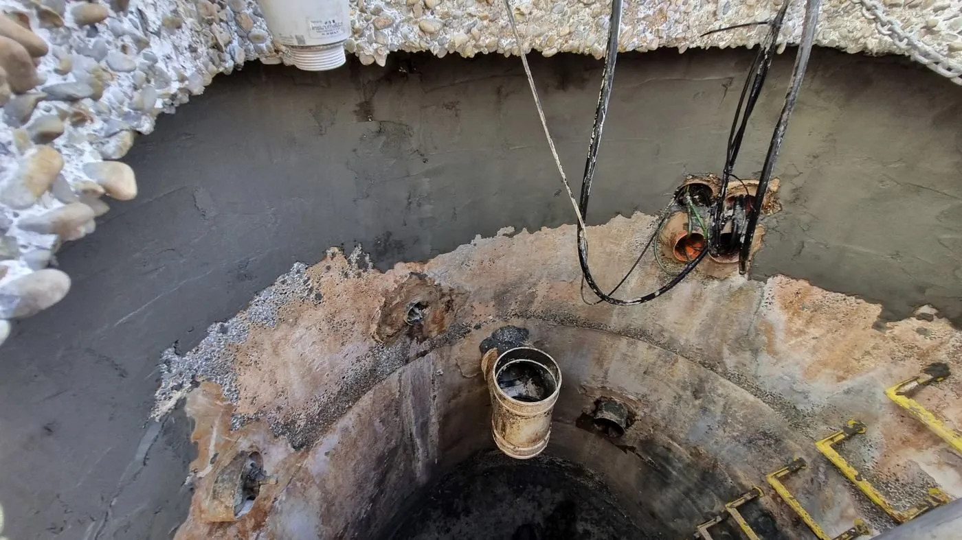Deteriorated concrete exposed inside a circular water structure during remediation